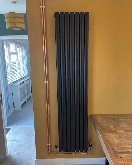 Vertical designer radiator with exposed copper pipework